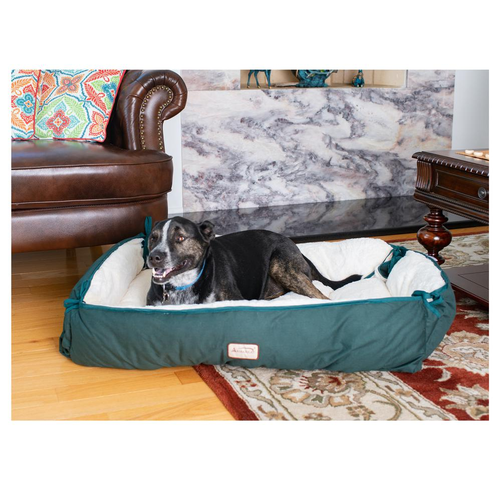 a green and white dog bed with pillows